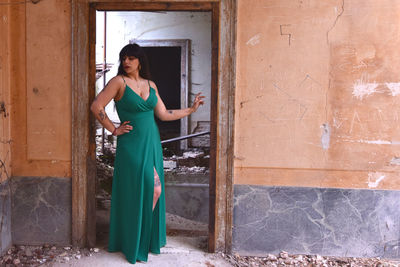 Full length of woman standing by abandoned building