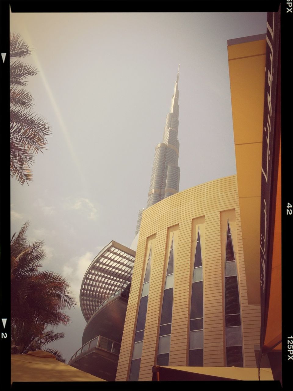 building exterior, architecture, built structure, transfer print, low angle view, auto post production filter, sky, city, place of worship, tower, tree, spirituality, day, church, outdoors, sunlight, religion, no people, clear sky, building