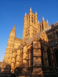 Exterior of lincoln cathedral in winter sunrise sunshine and blue sky