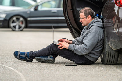 Low section of man sitting on road