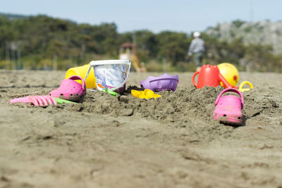 Shoes with sand toys on beach