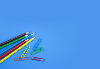 High angle view of colored pencils against blue background