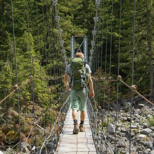 Rear view of man walking on footbridge