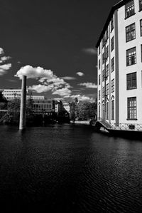 Buildings in city against cloudy sky