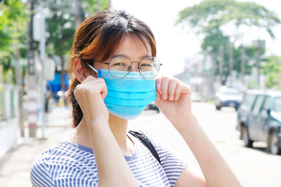 Portrait of woman drinking water from street