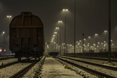 Train against sky at night during winter