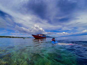 Man on boat in sea against sky