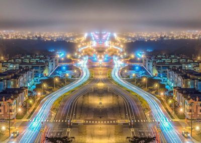 High angle view of light trails amidst buildings in city at night