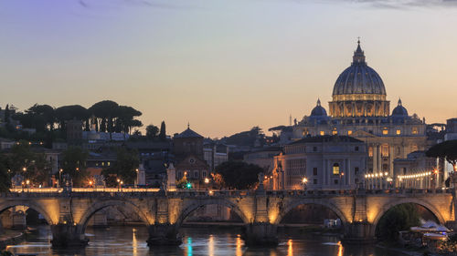 St peters basilica over tiber river during sunset in city