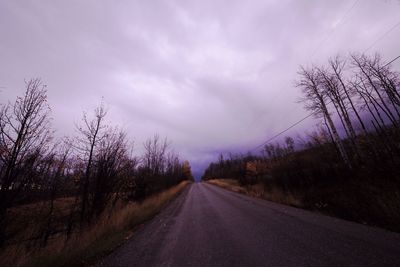 Empty road against cloudy sky