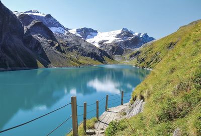 Scenic view of lake by mountains against sky