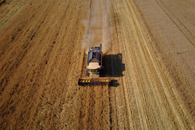 Scenic view of agricultural field with harvest combine