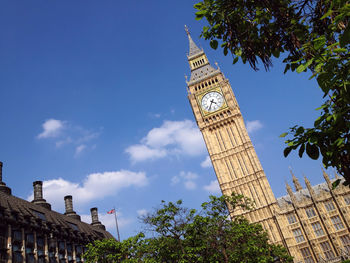 Low angle view of clock tower against blue sky