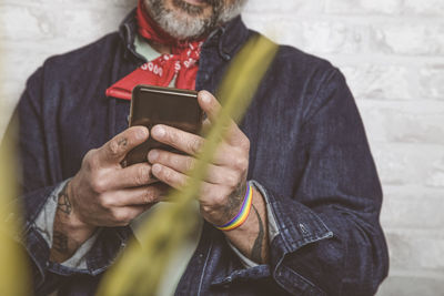 Close up view of smartphone in the hands of a smiling bearded hipster. mobile technology concept.