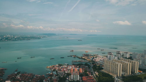 High angle view of city by sea against sky