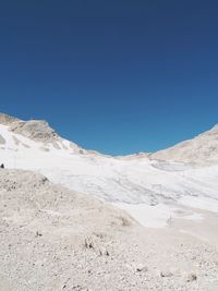 Scenic view of snowcapped mountains against clear blue sky