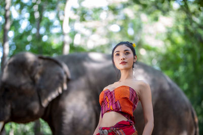 Full length of young woman against blurred trees