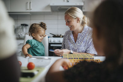 Mother and daughter spending time together playing game at home