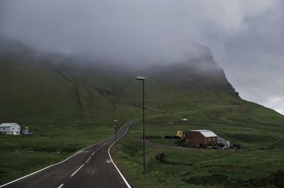 Road by mountains against sky