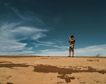 Full length of man standing on land against sky