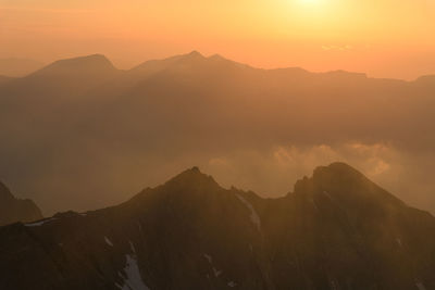 Scenic view of silhouette mountains against sky during sunset