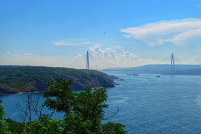 Suspension bridge over sea against sky