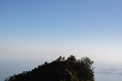 Hikers on mountain peak against sky