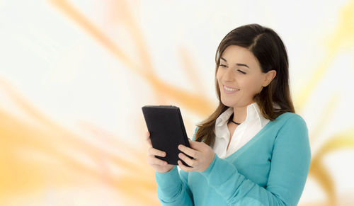 Smiling young woman using mobile phone