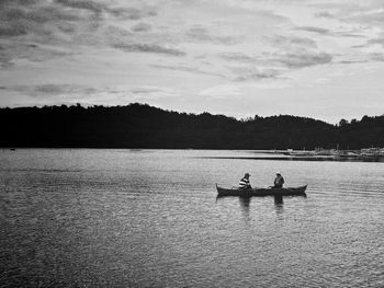 People in lake against sky