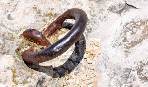 Close-up of rusty metal mounted on rock