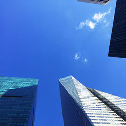 Low angle view of modern buildings against blue sky