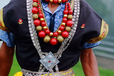 Midsection of man wearing jewelry while standing outdoors