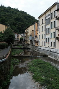 Canal amidst buildings against sky