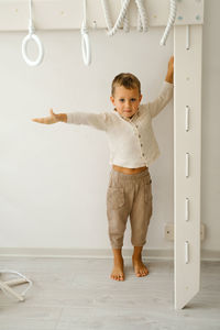 Child is exercising on toddler indoor gym playset. kid climbing the ladder in playroom. boy spending