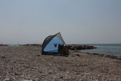 Tent on beach against clear sky