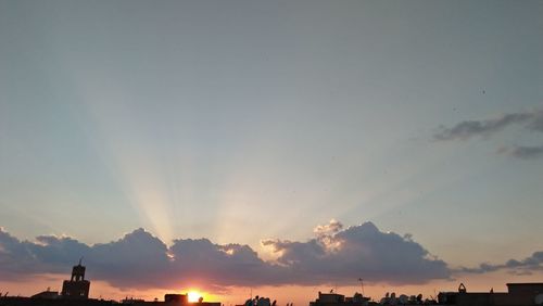 Silhouette buildings against sky during sunset