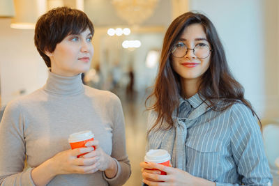 Beautiful women holding coffee cup at store