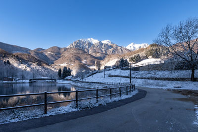 Road to small town beside a winter mountain lake
