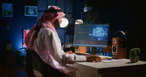 Side view of woman using laptop at office