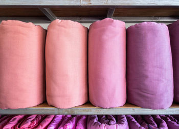 Close-up of pink textile stack in rack for sale