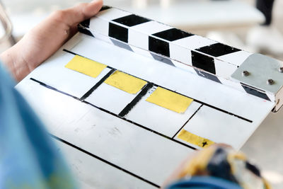 Midsection of man holding film slate while standing outdoors