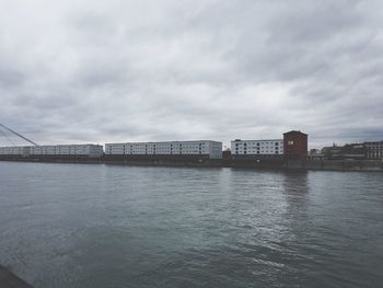 Bridge over river against sky in city