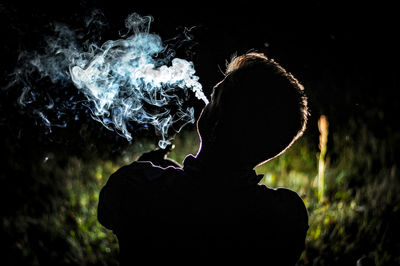 Rear view of silhouette man smoking