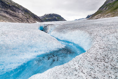 Scenic view of glacier on mountain against sky