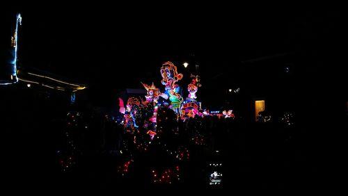 Illuminated christmas lights against sky at night