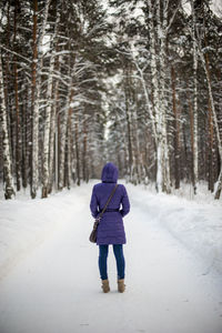 Rear view of woman walking in snow