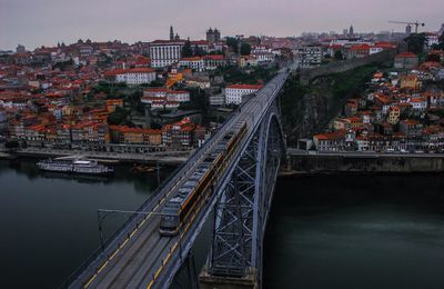 Bridge over river in city against sky