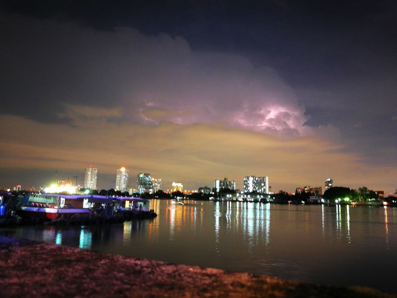 water, architecture, reflection, built structure, sky, waterfront, illuminated, city, river, cloud - sky, sunset, cityscape, outdoors, cloud, no people, nature, tranquility, scenics, beauty in nature, tranquil scene, cloudy, residential district, idyllic, city life