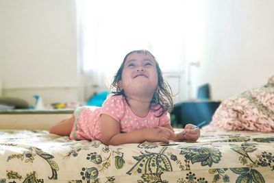 Smiling girl lying on bed at home