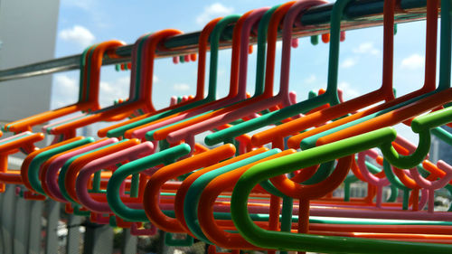 Close-up of multi colored chairs by swimming pool against sky